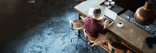 High angle shot of a businessman working on his laptop at the bar in a cafe