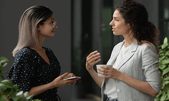 Two Female Colleagues Communicating Clay Optimised Card